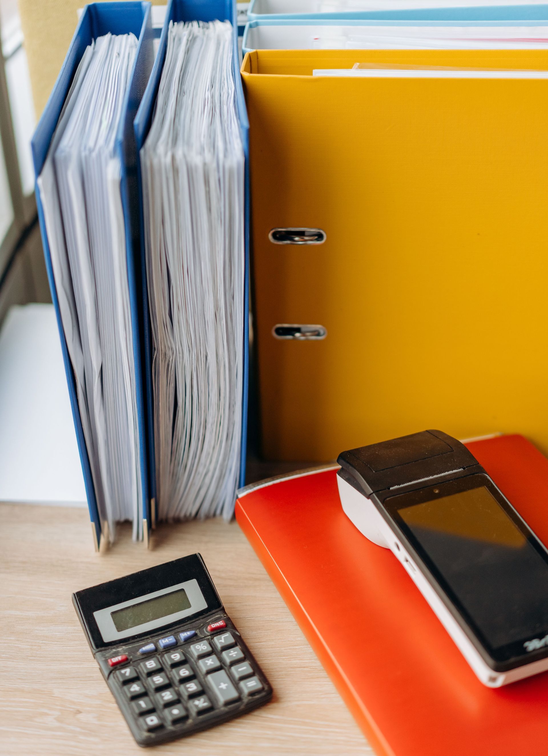 Organized office desk with a calculator, files, and documents for efficient work.